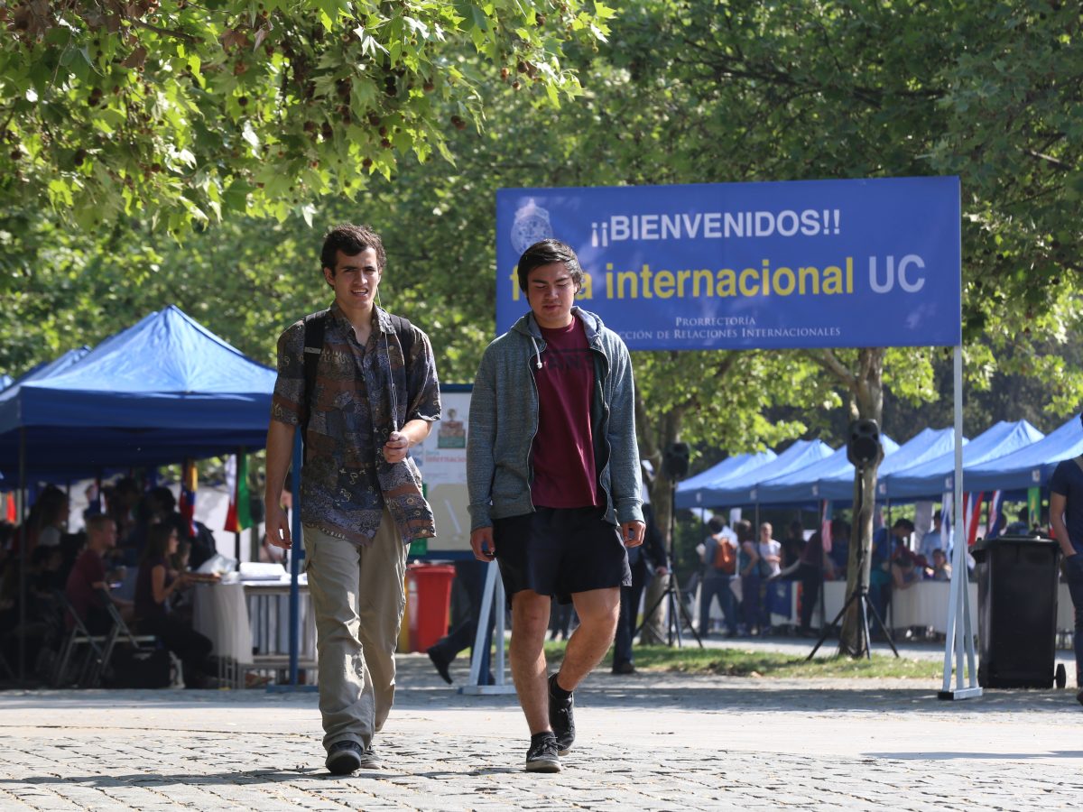 Dos estudiantes caminando en la Feria Internacional UC