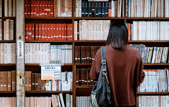 Mujer vista de espaldas, mirando una biblioteca