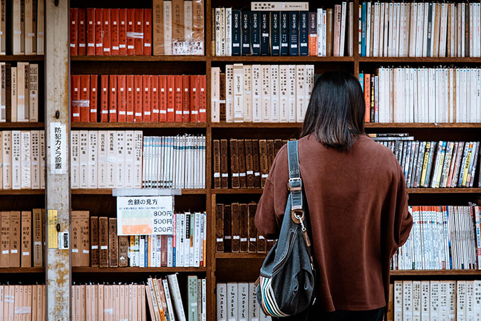 Mujer vista de espaldas, mirando una biblioteca