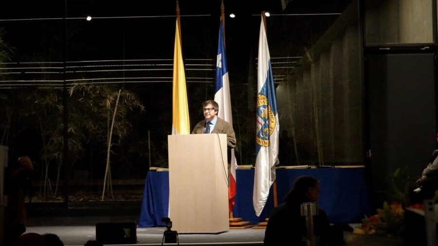 Decano Alejandro Carrasco entrega palabras desde el podio del auditorio. 