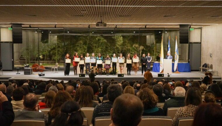 11 egresadas y egresados de PFP reciben su título en el escenario del auditorio.